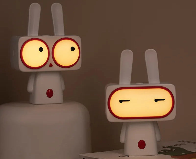 Two cartoon-style lamps with glowing faces on a dark background